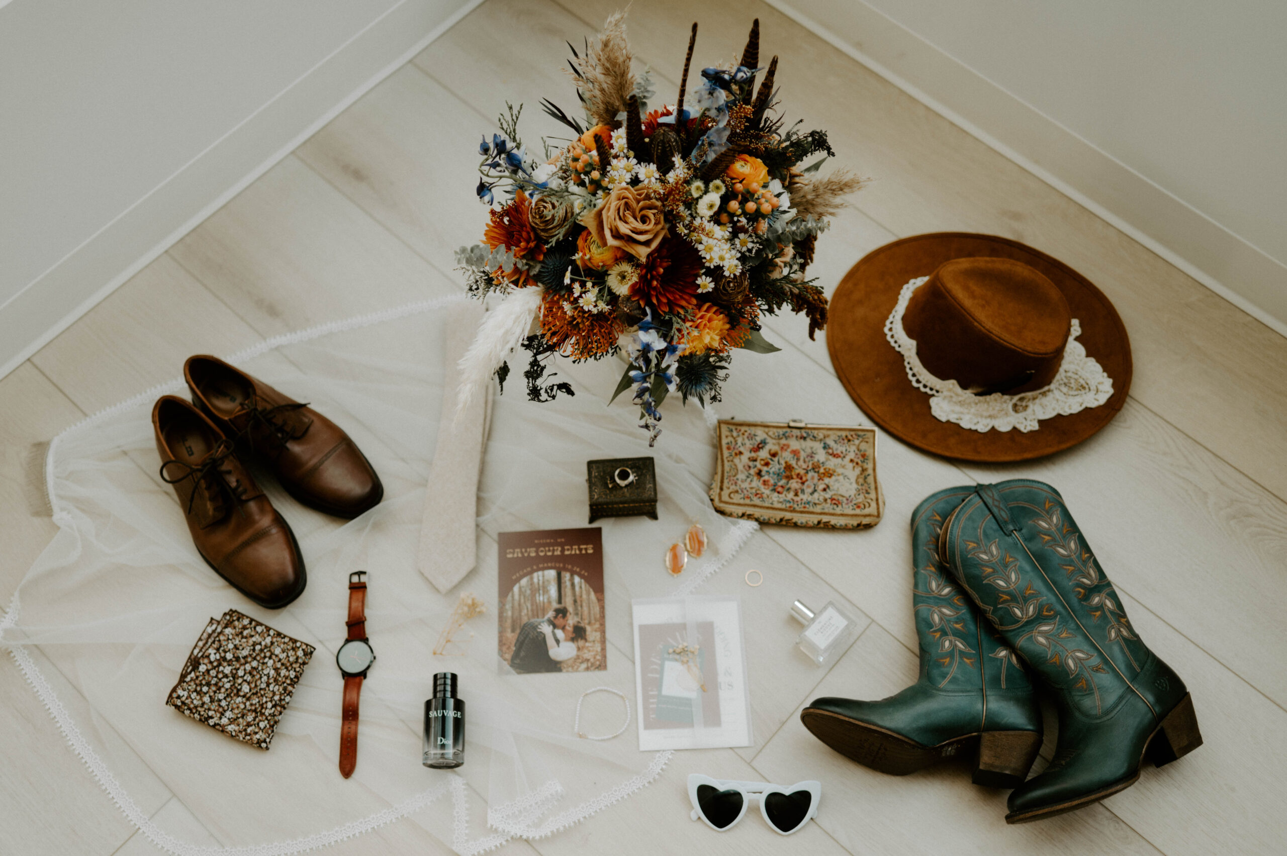 natalie tyler photography wedding details flatlay: florals, bouquet, purse, rings, invites, perfume, cologne, shoes, hat